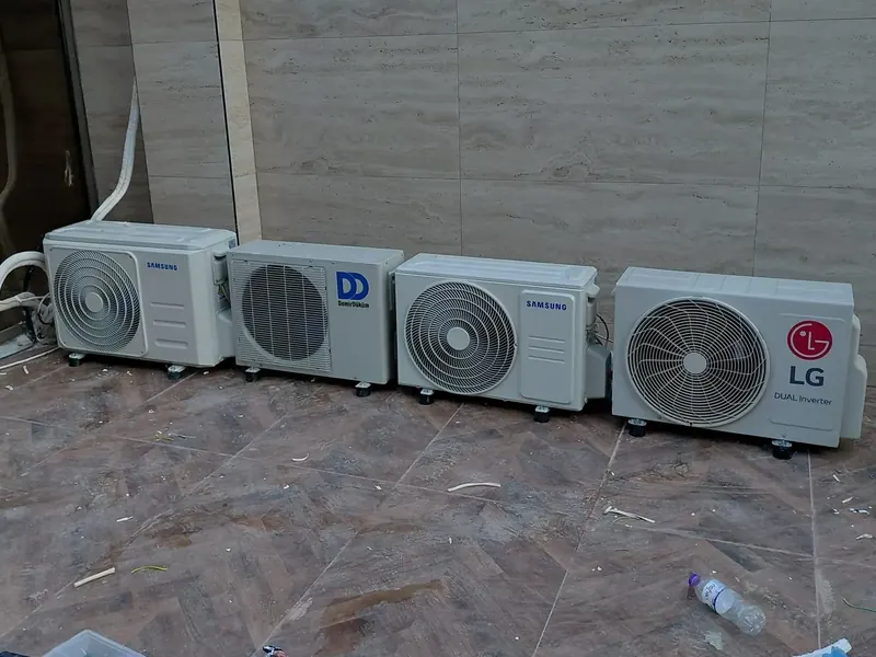 Four outdoor air conditioning units installed side by side on a terrace