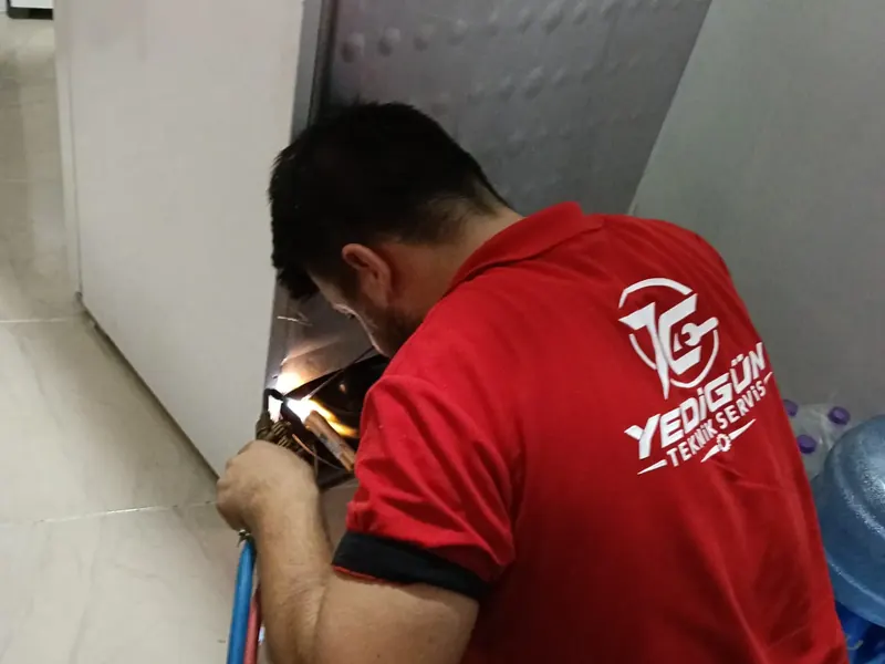 A Yedigün technician brazing a pipe on a fridge